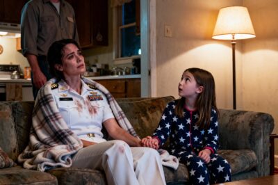 She was an Admiral lost in a storm of her own making, but the small, warm light of a stranger’s home held a truth colder than the rain.