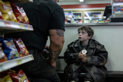 I thought it was just a pile of trash moving in the wind behind the dumpster. But when I kicked the cardboard aside, I stopped breathing. A single sneaker, split at the sole, was sticking out of the snow. Then I saw the eyes—dark, terrified, and freezing. He wasn’t hiding from the cold; he was hiding from something much worse. When I reached out to check for a pulse, he didn’t pull away. He just whispered three words that shattered my heart and made me realize this wasn’t an accident. It was a countdown.