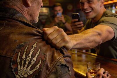 I watched my knuckles turn white as I gripped my beer, listening to the young Marine tear into the old man at the end of the bar. It wasn’t a fair fight. The kid was built like a tank, fresh off a tour, and the old guy looked like a strong breeze would knock him over. But it was the laughter that made my stomach turn—that cruel, mocking sound as he pointed a phone camera at the old man’s shaking hands. “Hey Grandpa,” he sneered, loud enough for the whole room to hear. “Did you buy that patch at a costume shop?” I wanted to say something. I really did. But I stayed silent, and that silence is something I’ll have to live with for the rest of my life.